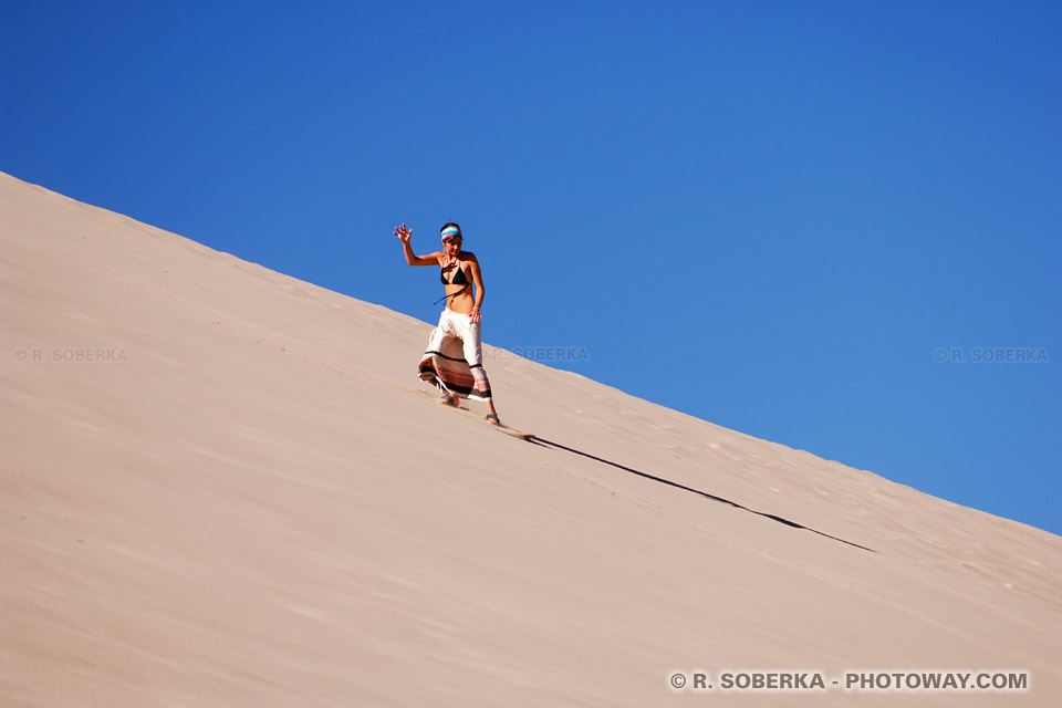 Image du surf dans les dunes : photos d'un surfeuse dans le sable